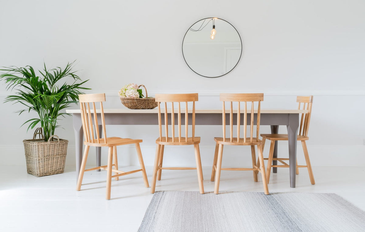 The Folde dining table with grey legs and six chairs round it, showing how the chairs sit between the legs
