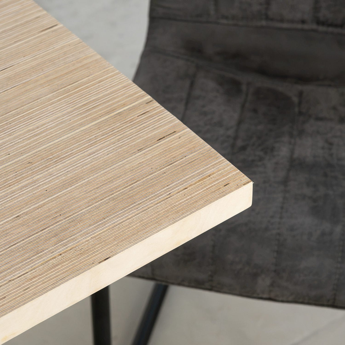 Corner of an edge-grain plywood table top showing the layered ply edge
