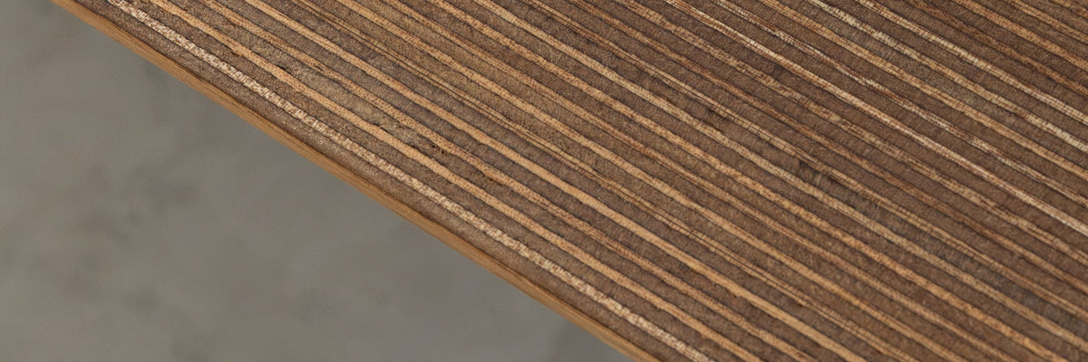 Close-up of an edge-grain plywood table top showing the layered ply edge